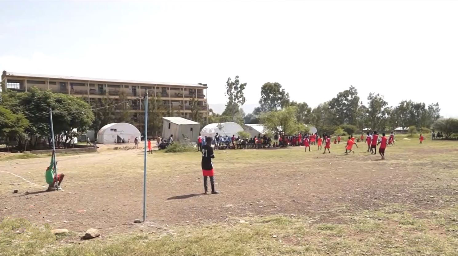 Children and young men playing football in Ethiopia