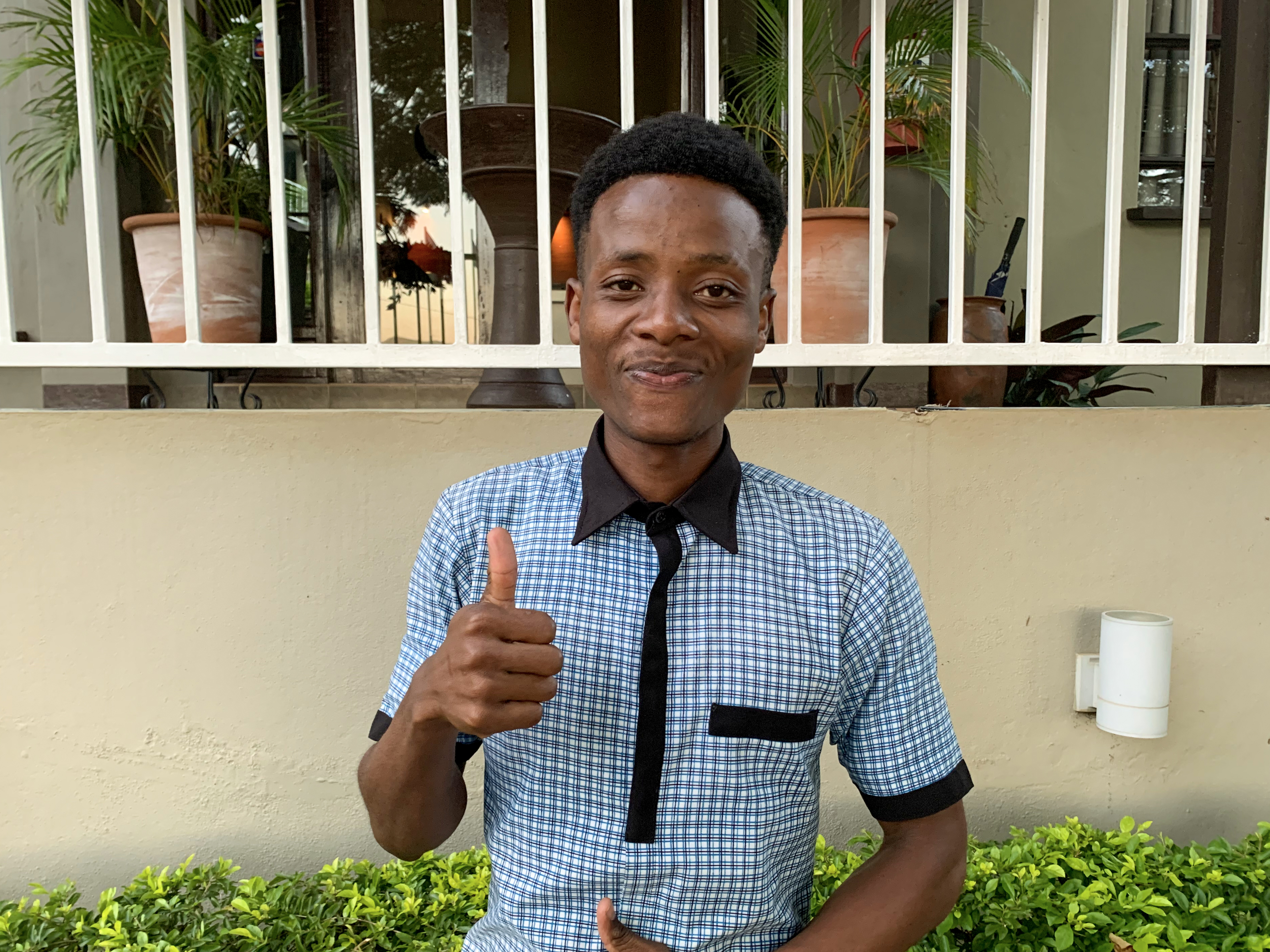 young man giving thumbs up to the camera
