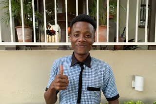 young man giving thumbs up to the camera