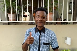 young man giving thumbs up to the camera