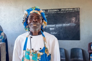 a man dressed in bright cook's attire smiling for the camera