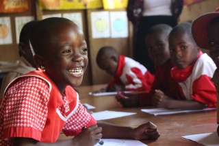 close up of a young girl laughing at her school desk