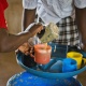 A volunteer from Zambia serving Mary's Meals to children at school. 