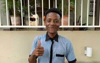young man giving thumbs up to the camera