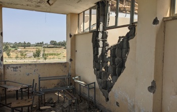 Image looking out of a building which has been left in ruin after the recent conflict.