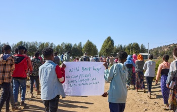 Children holding up a sign asking for help.