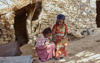 Fitsum and Aradech sitting outside their home.