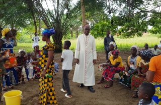 Bishop Karnley walking amongst a group of children outdoors