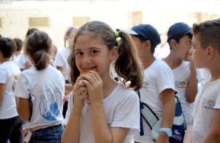 A girl smiles as she eats in Syria