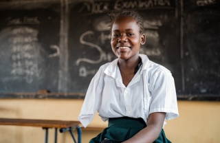 young girl in class smiling as she poses for a photo