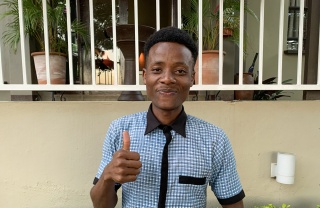 young man giving thumbs up to the camera