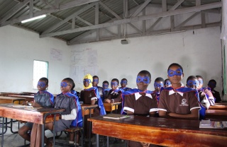 classroom full of children dressed as superheroes with capes and masks