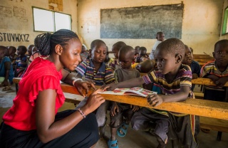 A teacher attends to pupils in Kenya