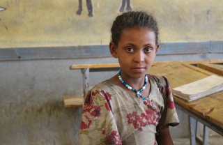 Image of Mahlet sitting in a classroom looking into camera. 