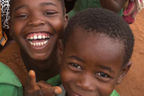 Two children smiling and looking into camera.