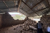 Image of a storage shed shown to have been destroyed after recent fighting. Two walls can be seen to have collapsed.