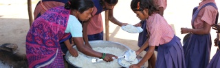 a group of volunteers leaning over a large pot