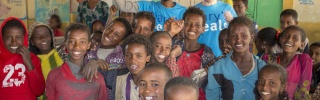 children and Mary's Meals volunteers posing for a photo