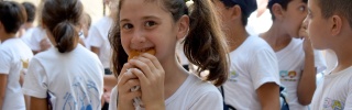 A girl smiles as she eats in Syria