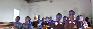 classroom full of children dressed as superheroes with capes and masks