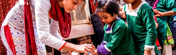 A volunteer washes children's hands in India