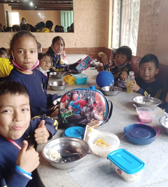 children in class round a table eating food