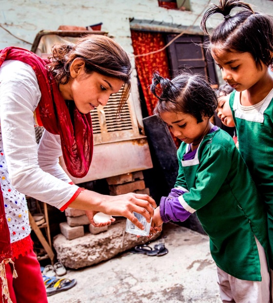 A volunteer washes children's hands in India