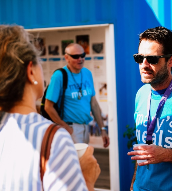 Two Mary's Meals supporters talking to each other outside the Mary's Meals information centre in Medjugorje.