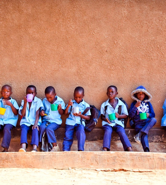 Children sit outside their school in Zambia