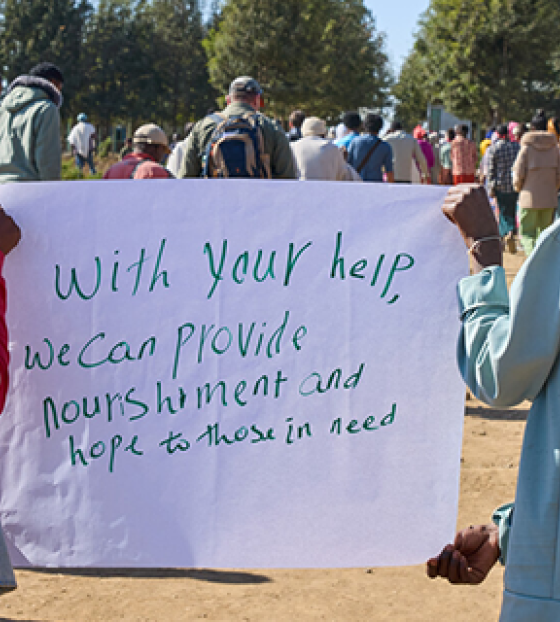Children holding up a sign asking for help.