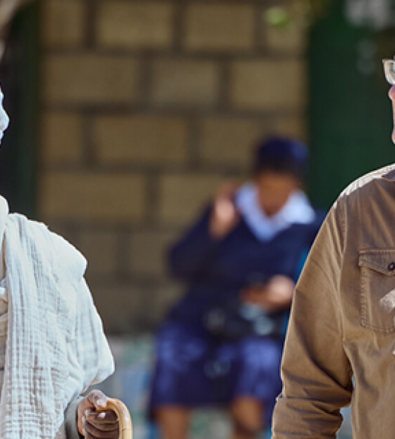 Image of Mary's Meals founder Magnus MacFarlane-Barrow walking with a village elder in Tigray.