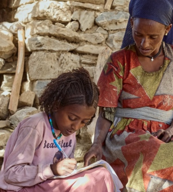 Fitsum and Aradech sitting outside their home.