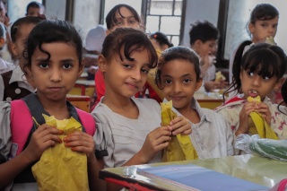 young girls posing for a photo eating food