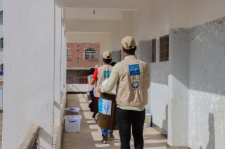 aid workers standing in a line carrying equipment