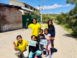 a group of children posing for the camera and giving 'peace' signs