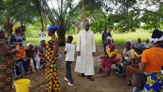 Bishop Karnley walking amongst a group of children outdoors