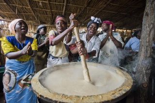 Mary's Meals volunteer cooks from Malawi preparing porridge to serve to school children. 