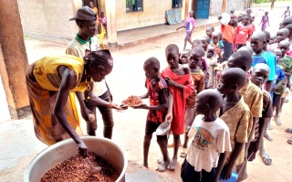 A volunteers serves food to children in South Sudan