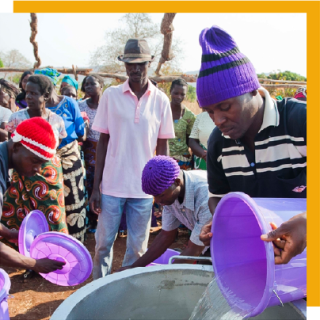 volunteers pouring water into a larger container