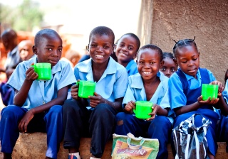 Children in Zambia enjoy mugs of porridge