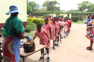 a line of school children collecting food