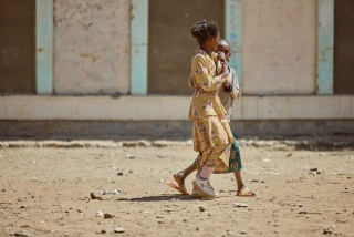 Image of two girls walking outside of Gendet Primary School.