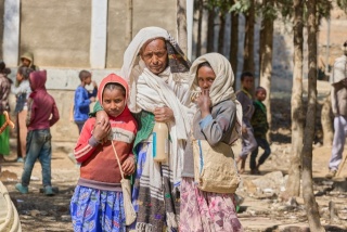 A father with his two children at Gendet Primary School.