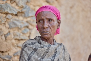 Letemariam pictured looking off beyond the camera against the backdrop of a stone wall.
