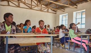 Children sitting inside a classroom.