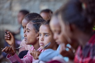 Children eating at Beati Akor primary school.