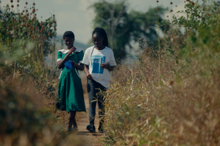 Lettie walking with a young person in Malawi.